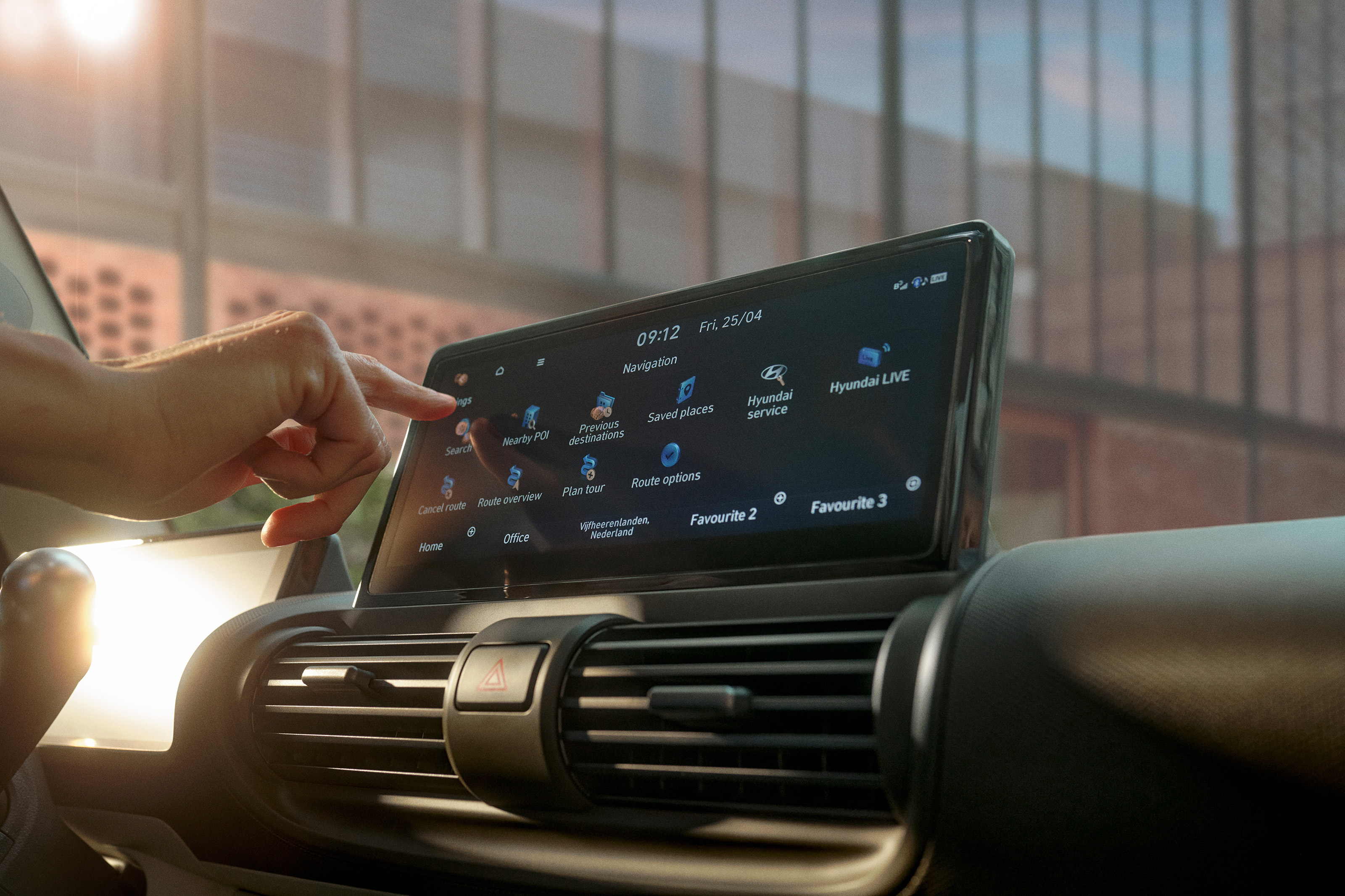 Hand touching the center touchscreen to navigate menus and map options on the INSTER display.
